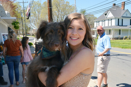Girl holding dog in downtown Cleveland, North Carolina