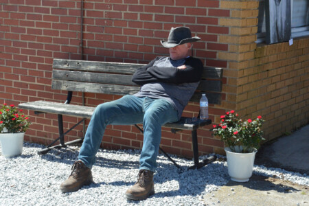 Man relaxing on a park bench in downtown Cleveland, North Carolina