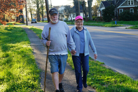Older couple walking on a sidewalk hand-in-hand in Cleveland, North Carolina